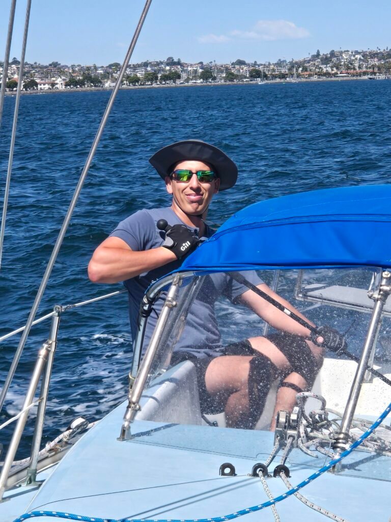 Student steering Wolf by tiller extention on San Diego Bay